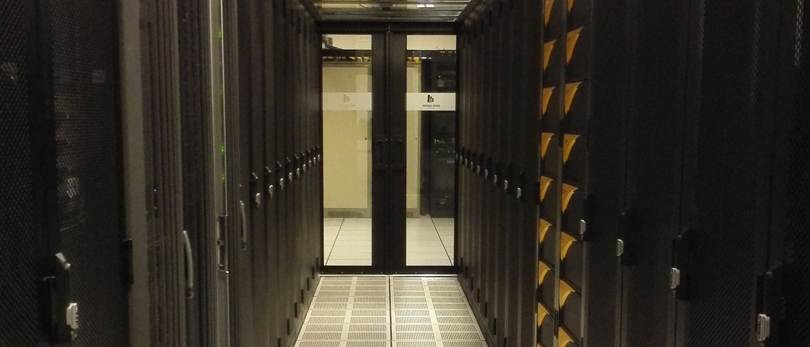 Corredor de um centro de dados com filas de bastidores de servidores